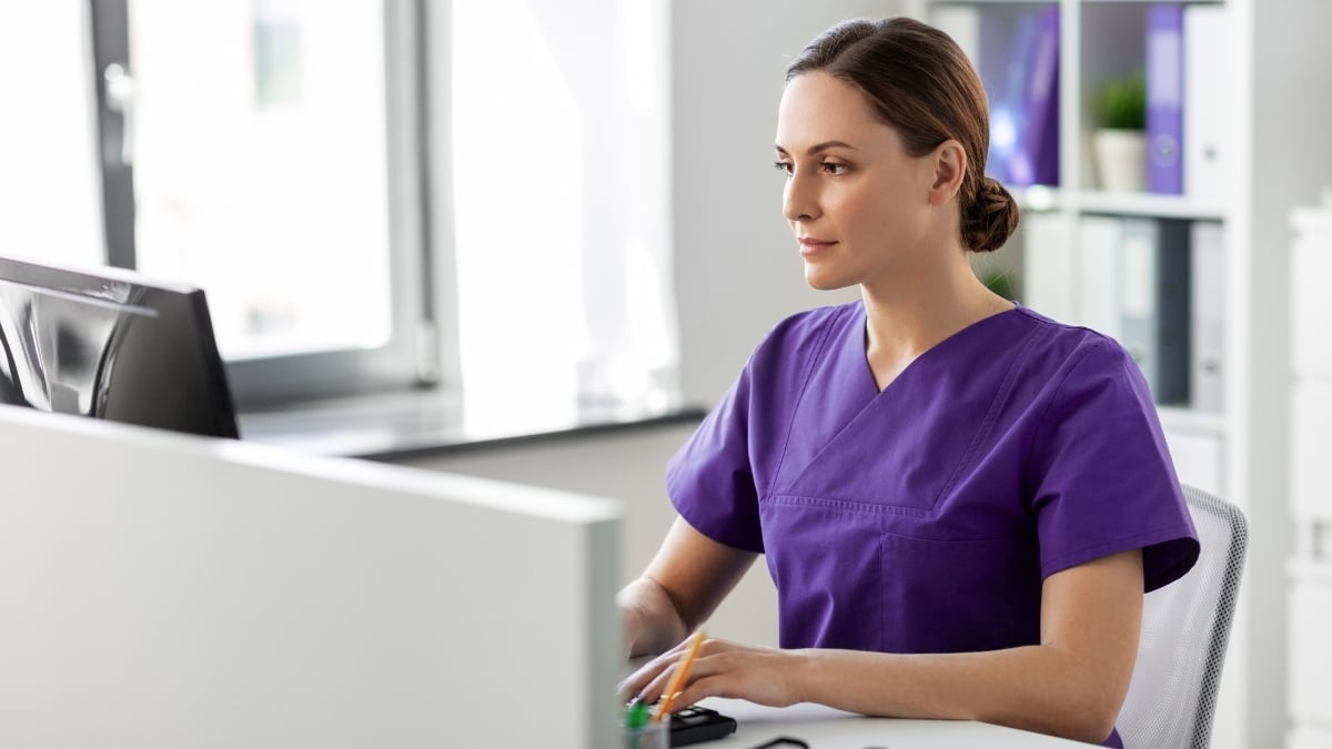 Clinician typing and reviewing information on computer.
