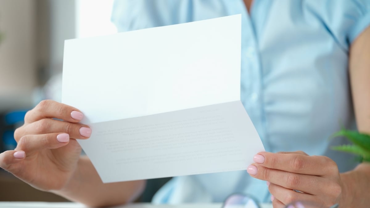 Person holding a paper letter.