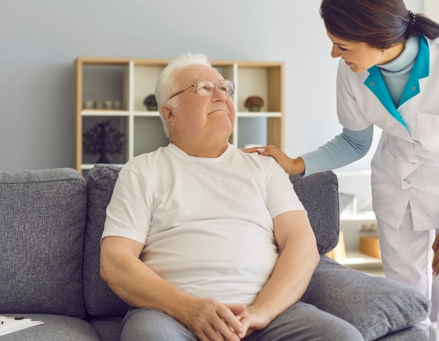 Elderly patient Bart speaks with his home health caregiver.