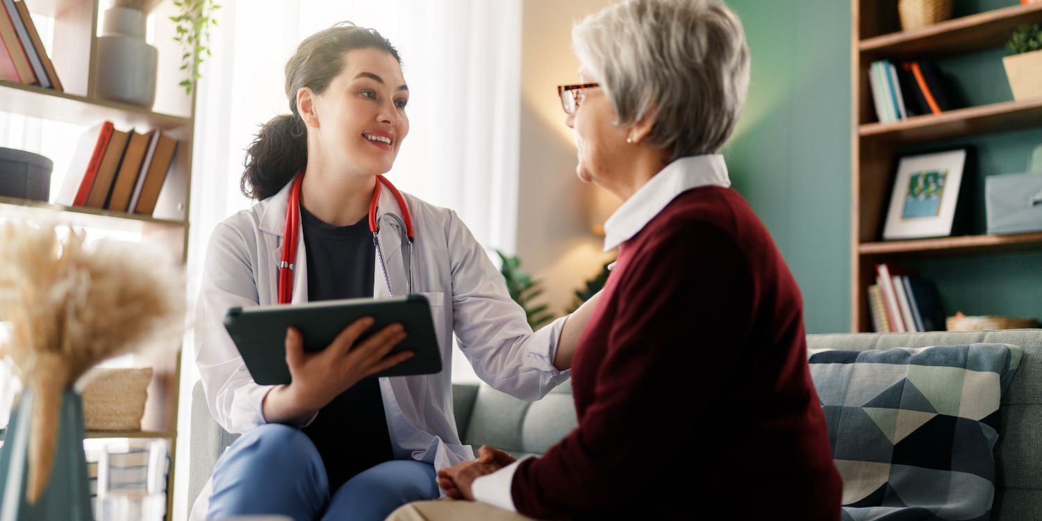 Automation in Care-at-home, female nurse on tablet with a older female patient in the home