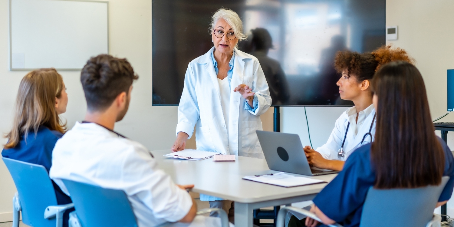 clinicians gathered around a table discussing technology