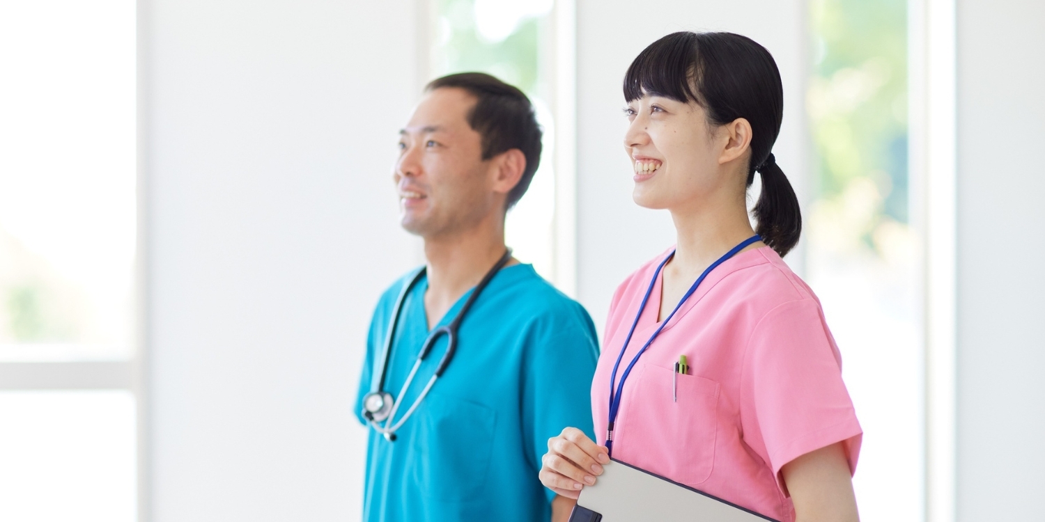 Two clinicians looking ahead with bright smiles.