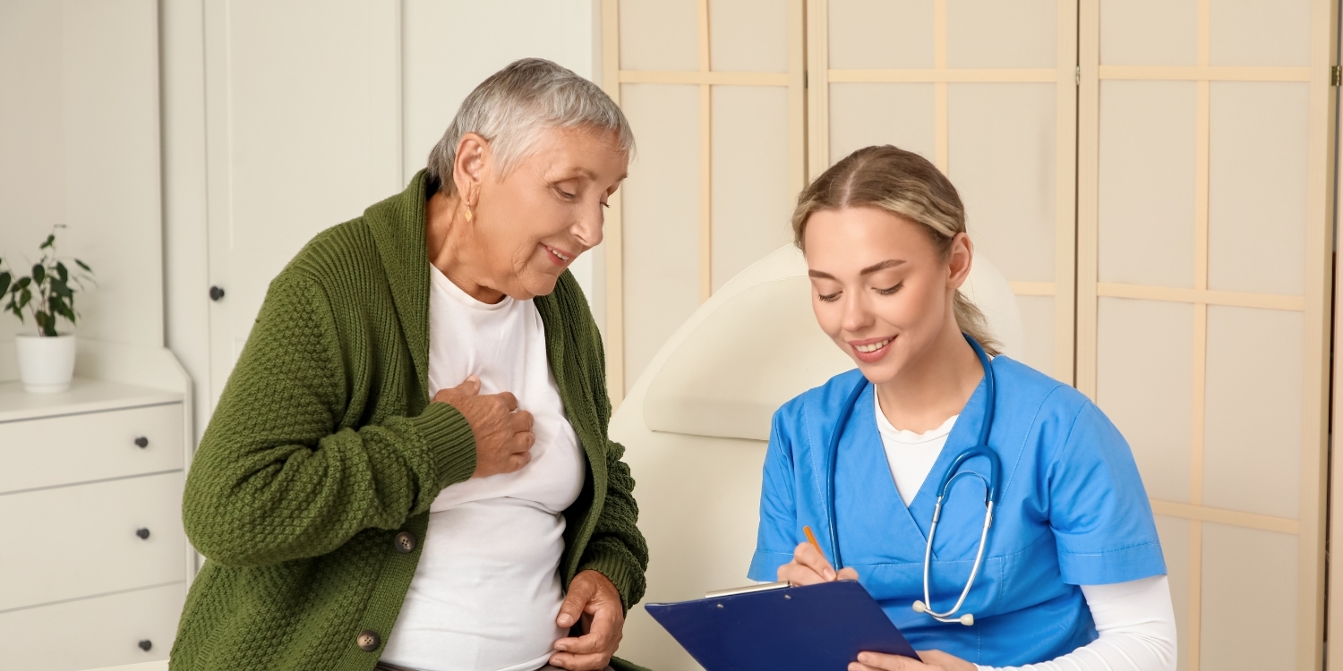 Hospice caregiver with senior patient and filling out a form.