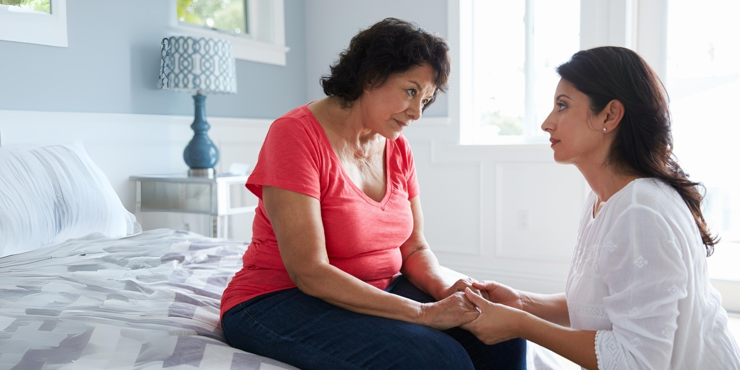 Caregiver holding an elderly woman's hands.