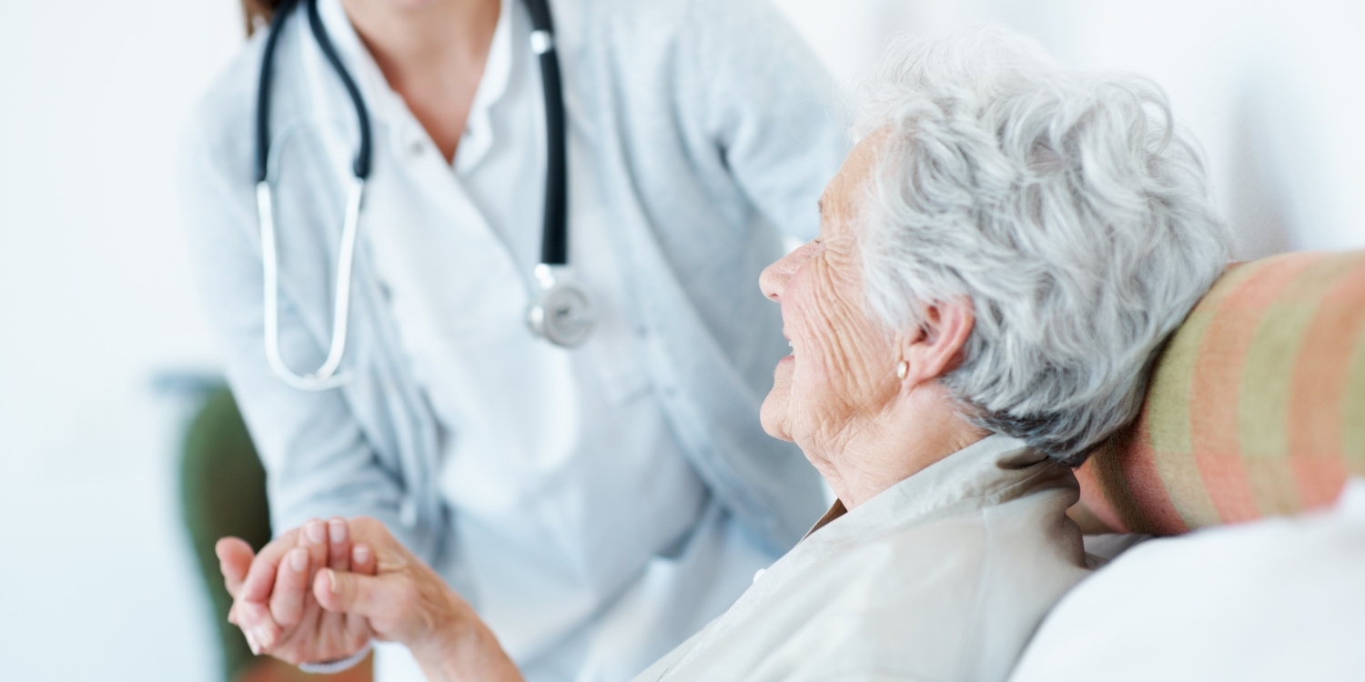 caregiver holding elderly patient's hand
